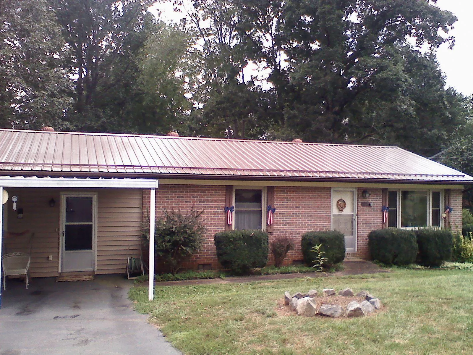 Bronze metal roof and carport on a brick ranch home — Roof Repair work by our crew in Sebring